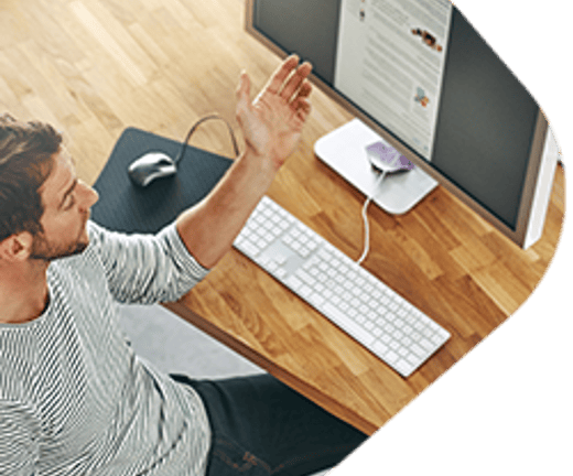 Man at a desk looking at a computer monitor.